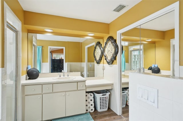 bathroom featuring a shower with shower door, vanity, and hardwood / wood-style flooring