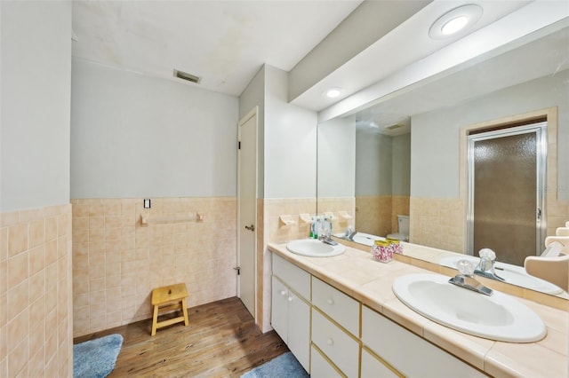 bathroom featuring toilet, tile walls, hardwood / wood-style floors, and vanity