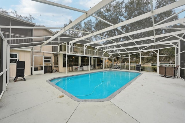 view of swimming pool featuring glass enclosure and a patio area