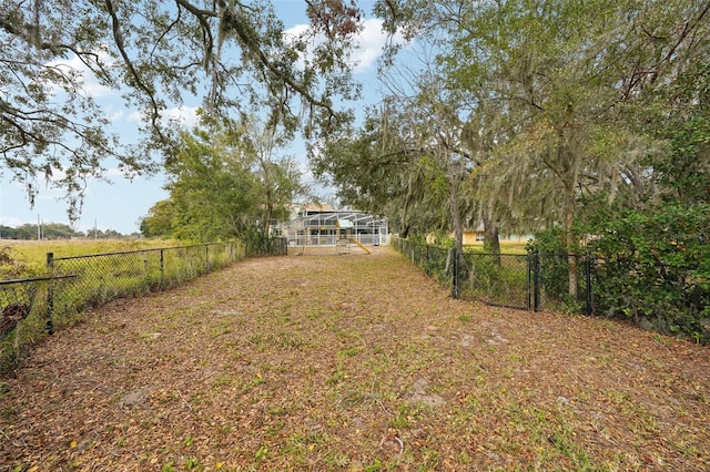 view of yard with a lanai and a rural view