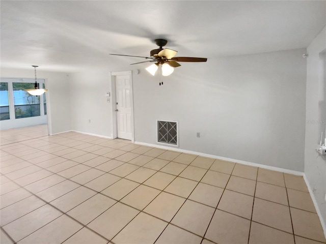 tiled spare room featuring ceiling fan