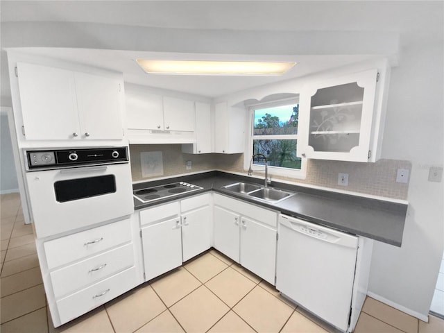 kitchen featuring white appliances, white cabinets, decorative backsplash, sink, and light tile patterned floors