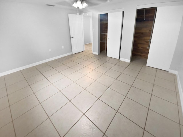 unfurnished bedroom with ceiling fan and light tile patterned floors