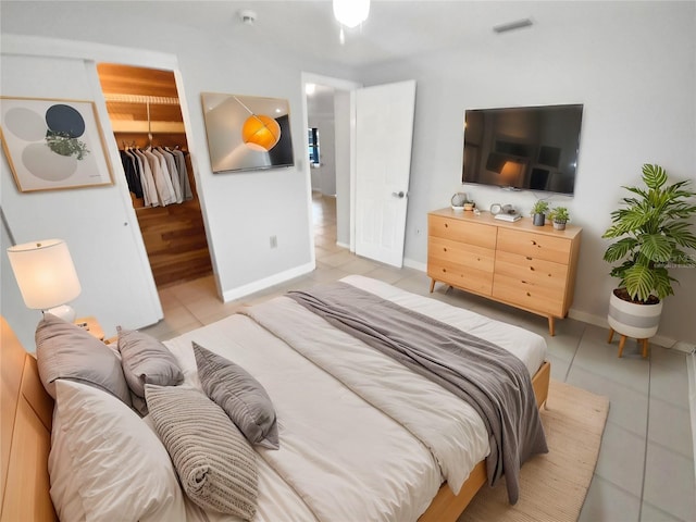 bedroom featuring light tile patterned floors, a closet, and a walk in closet