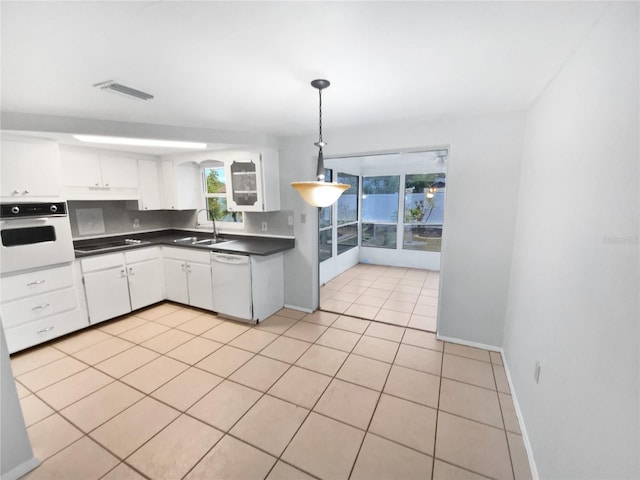 kitchen with light tile patterned floors, backsplash, decorative light fixtures, white appliances, and white cabinets