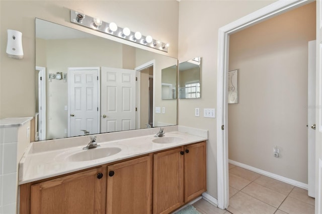 bathroom featuring tile patterned floors, double vanity, baseboards, and a sink