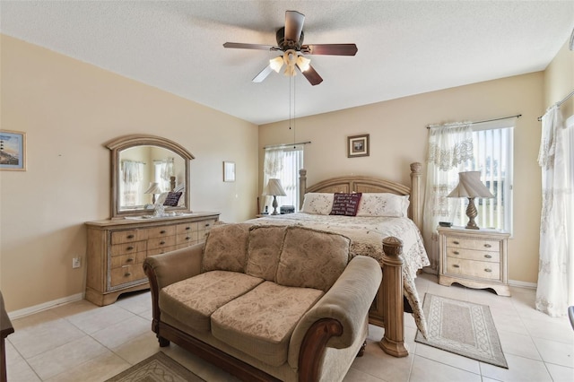 bedroom featuring baseboards, a textured ceiling, light tile patterned flooring, and a ceiling fan