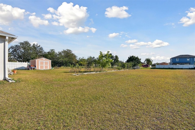 view of yard with a storage shed, an outdoor structure, and fence