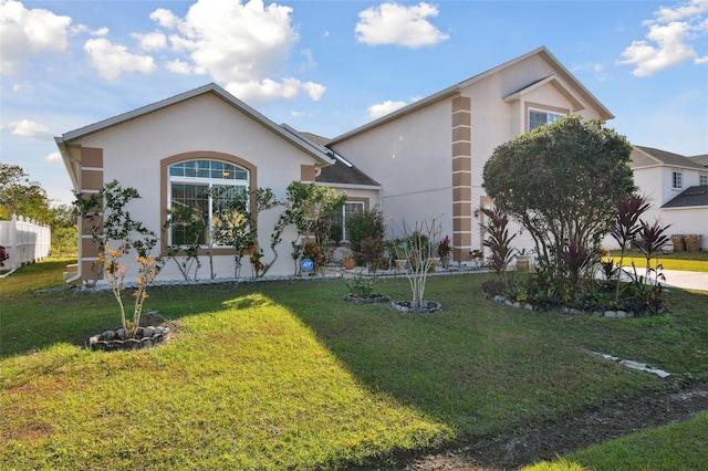 view of front of home featuring a front yard and stucco siding