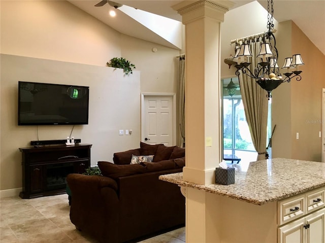 living room with high vaulted ceiling, ornate columns, and a notable chandelier