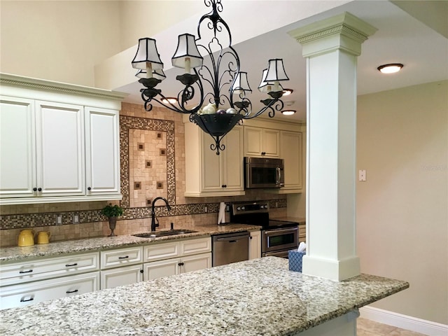 kitchen featuring appliances with stainless steel finishes, ornate columns, decorative backsplash, sink, and light stone counters