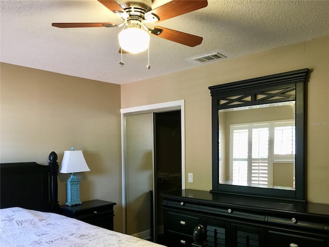 bedroom featuring a textured ceiling, a closet, and ceiling fan