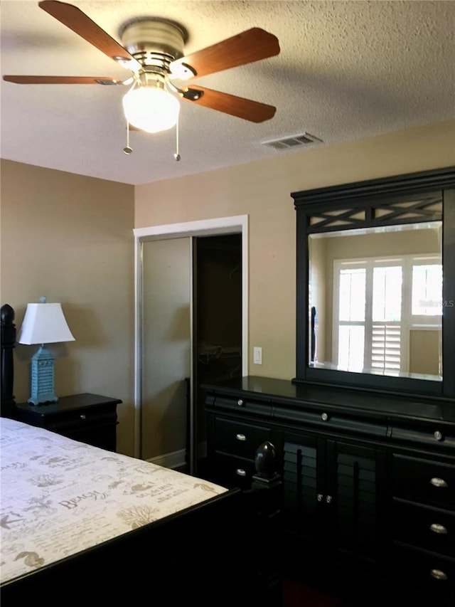 bedroom featuring a textured ceiling, a closet, and ceiling fan