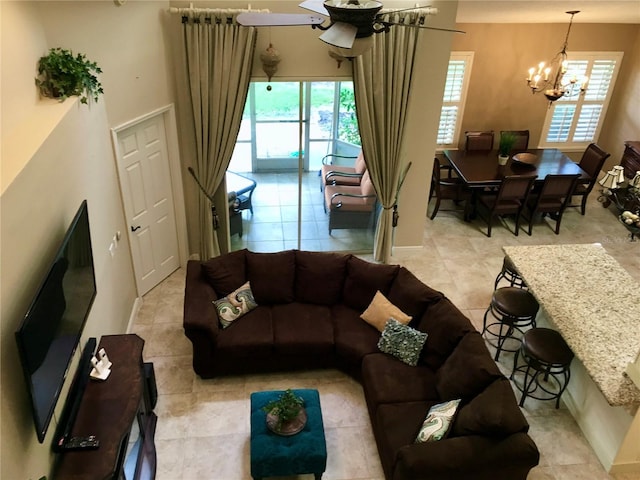 tiled living room featuring plenty of natural light and a chandelier