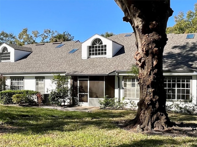 back of property featuring a yard and a sunroom