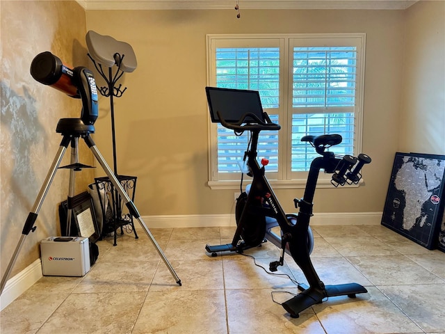 exercise room with crown molding and light tile patterned flooring