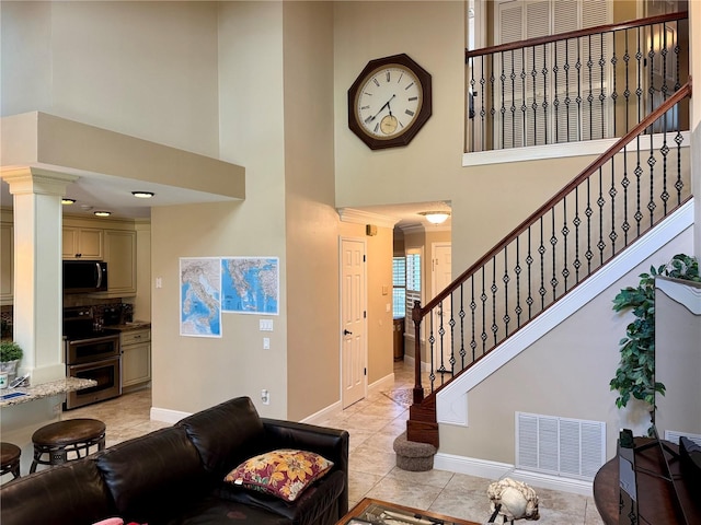 interior space featuring a towering ceiling and decorative columns