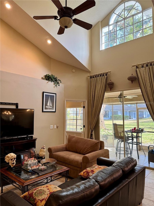 tiled living room featuring ceiling fan, a healthy amount of sunlight, and high vaulted ceiling