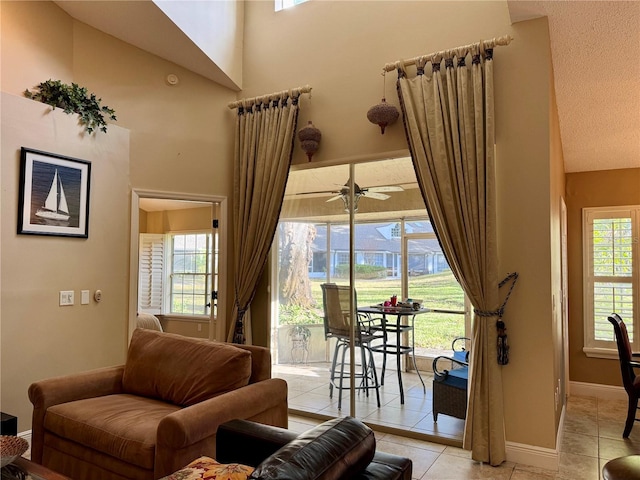 tiled living room featuring a high ceiling and ceiling fan