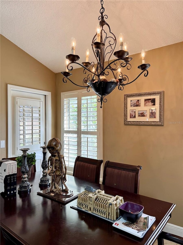 dining room featuring vaulted ceiling, a chandelier, and a textured ceiling