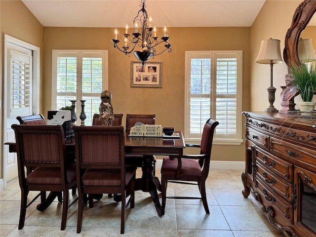 dining room featuring light tile patterned flooring, a healthy amount of sunlight, and an inviting chandelier