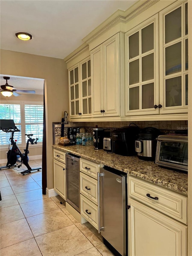 kitchen featuring refrigerator, wine cooler, cream cabinets, light stone countertops, and light tile patterned flooring