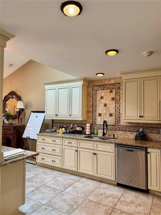 kitchen featuring cream cabinets, sink, stainless steel dishwasher, and decorative backsplash