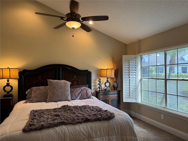 bedroom with lofted ceiling, ceiling fan, carpet floors, and a textured ceiling