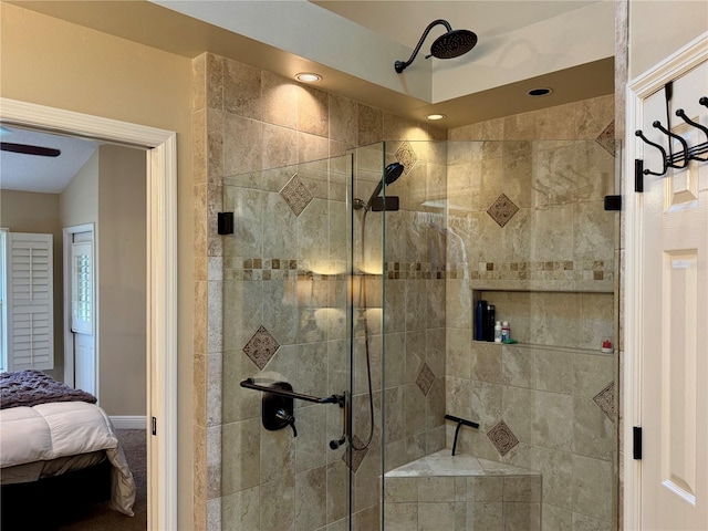 bathroom featuring ceiling fan and a shower with door