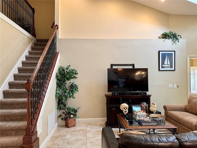 living room featuring a towering ceiling and light tile patterned floors