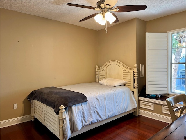 bedroom featuring dark hardwood / wood-style flooring, ceiling fan, and a textured ceiling