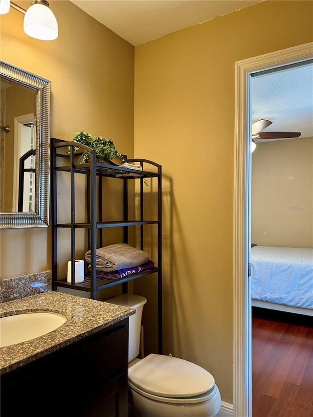 bathroom featuring ceiling fan, vanity, toilet, and wood-type flooring