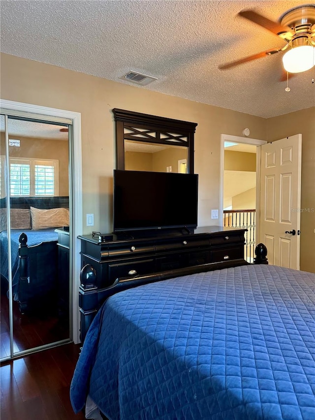 bedroom featuring hardwood / wood-style flooring, ceiling fan, and a textured ceiling