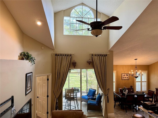 living room featuring ceiling fan with notable chandelier, high vaulted ceiling, and a healthy amount of sunlight