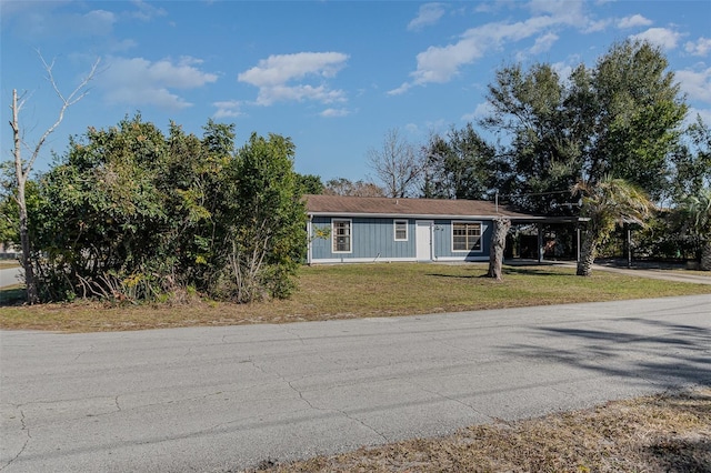 view of front of property with a front lawn and a carport