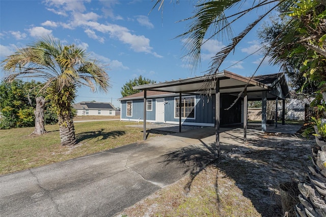 view of front of home with a front yard and a carport