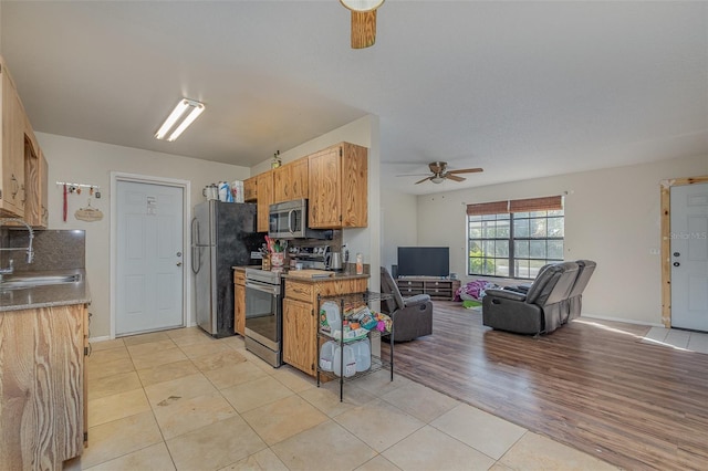 kitchen featuring sink, light tile patterned floors, ceiling fan, and stainless steel appliances