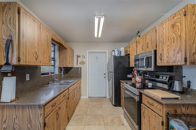 kitchen featuring decorative backsplash, sink, light tile patterned floors, and stainless steel appliances