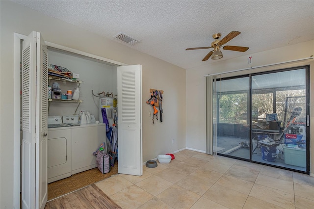 laundry room featuring ceiling fan, light tile patterned floors, a textured ceiling, and washer and dryer