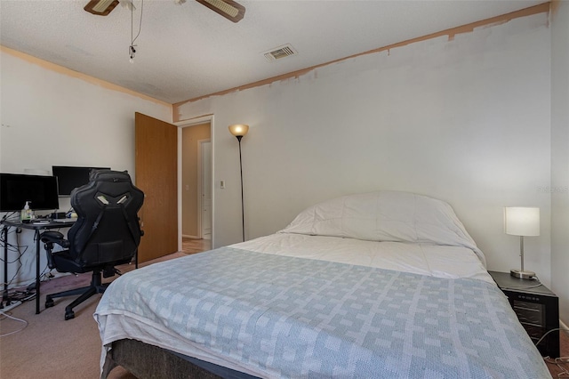 bedroom with light carpet, ceiling fan, and a textured ceiling