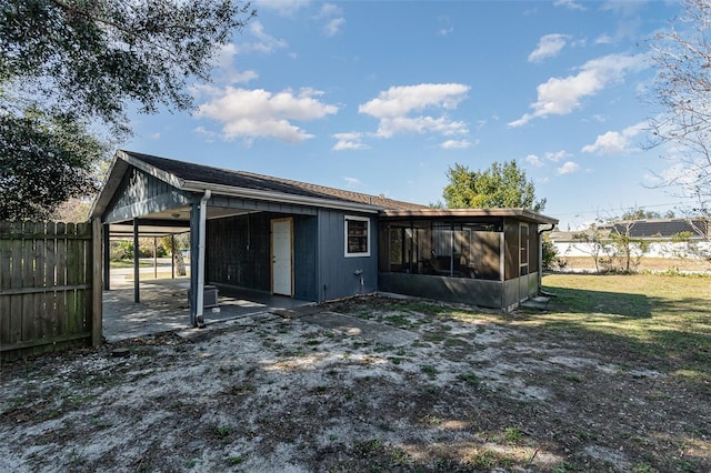 rear view of house with a sunroom and a lawn