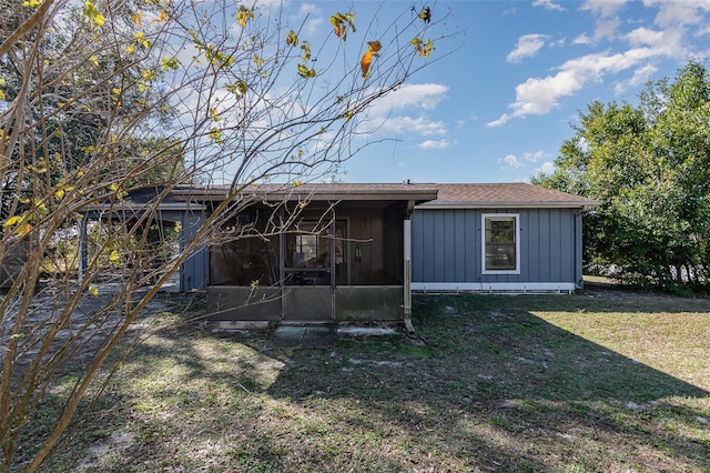 rear view of property featuring a sunroom and a lawn