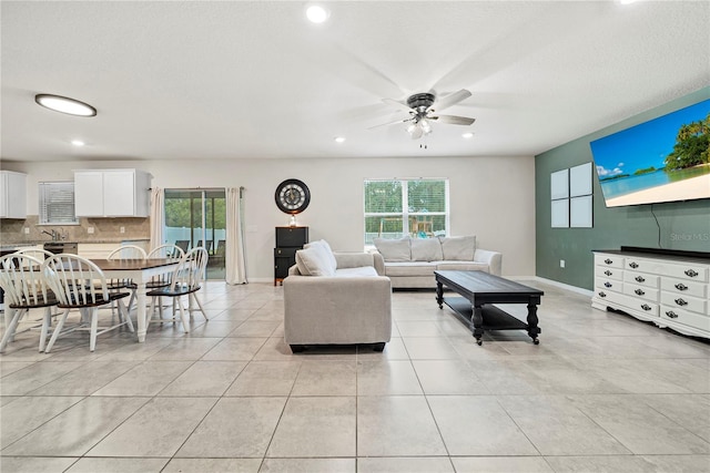 living room featuring light tile patterned flooring, plenty of natural light, and ceiling fan