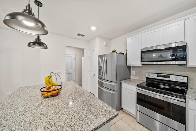 kitchen with white cabinetry, light stone counters, tasteful backsplash, and stainless steel appliances