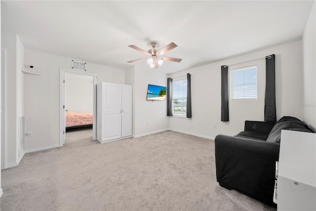 living area with light colored carpet and ceiling fan