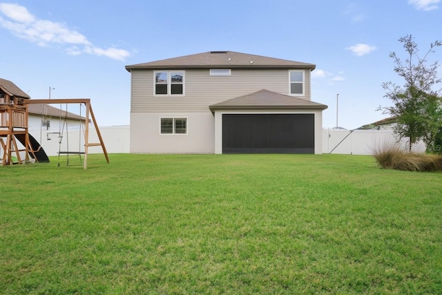 back of house featuring a lawn and a playground