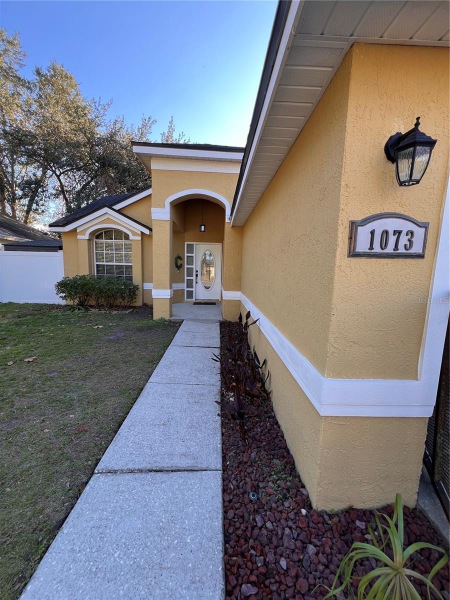 doorway to property with a lawn