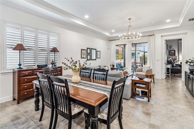 dining area featuring a raised ceiling, an inviting chandelier, and crown molding