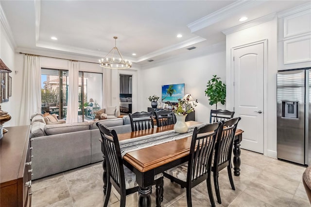 dining room featuring ornamental molding, an inviting chandelier, and a tray ceiling