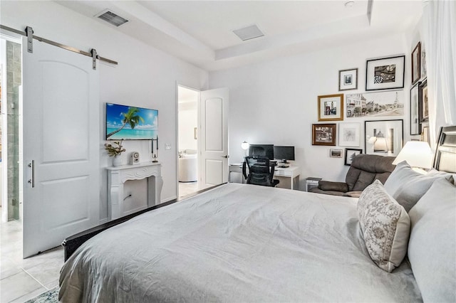 tiled bedroom with a raised ceiling and a barn door